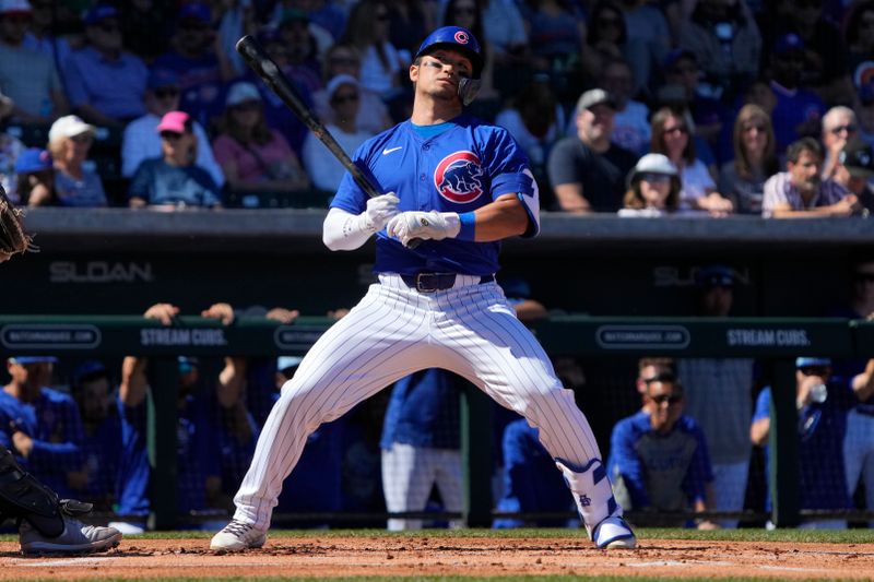 Mar 1, 2024; Mesa, Arizona, USA; Chicago Cubs right fielder Seiya Suzuki (27) leans out of the way against the Chicago White Sox during the first inning at Sloan Park. Mandatory Credit: Rick Scuteri-USA TODAY Sports