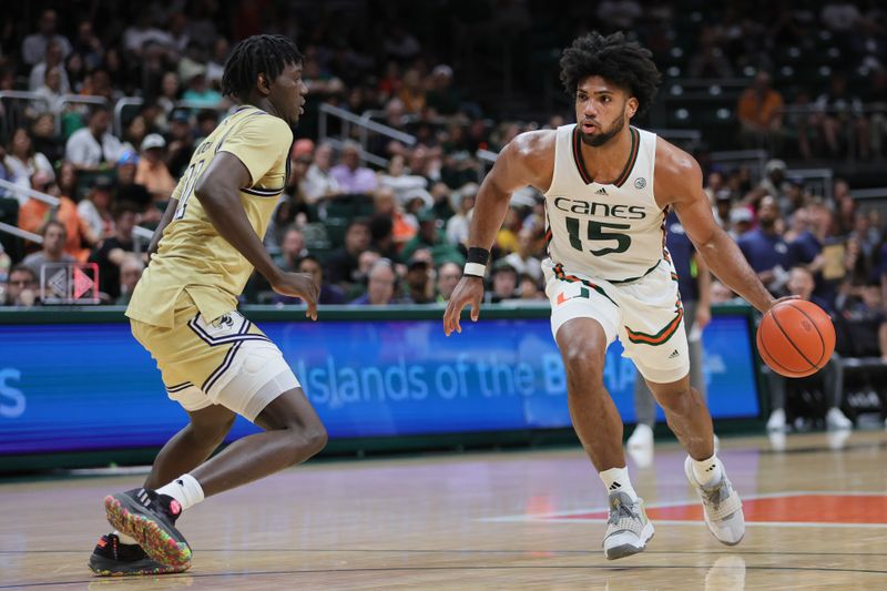 Feb 24, 2024; Coral Gables, Florida, USA; Miami Hurricanes forward Norchad Omier (15) dribbles the basketball as Georgia Tech Yellow Jackets forward Baye Ndongo (11) defends during the second half at Watsco Center. Mandatory Credit: Sam Navarro-USA TODAY Sports
