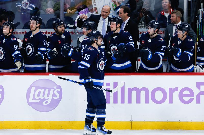 Dec 3, 2024; Winnipeg, Manitoba, CAN;  Winnipeg Jets forward Mark Scheifele (55) is congratulated by his team mates on his goal against the St. Louis Blues during the third period at Canada Life Centre. Mandatory Credit: Terrence Lee-Imagn Images