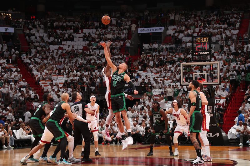 MIAMI, FL - APRIL 27: Bam Adebayo #13 of the Miami Heat and Kristaps Porzingis #8 of the Boston Celtics go up for the opening tip off during Round 1 Game 3 of the 2024 NBA Playoffs on April 27, 2024 at Kaseya Center in Miami, Florida. NOTE TO USER: User expressly acknowledges and agrees that, by downloading and or using this Photograph, user is consenting to the terms and conditions of the Getty Images License Agreement. Mandatory Copyright Notice: Copyright 2024 NBAE (Photo by Issac Baldizon/NBAE via Getty Images)