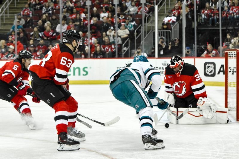 Nov 10, 2024; Newark, New Jersey, USA; New Jersey Devils goaltender Jake Allen (34) makes a save against San Jose Sharks center Mikael Granlund (64) during the third period at Prudential Center. Mandatory Credit: John Jones-Imagn Images