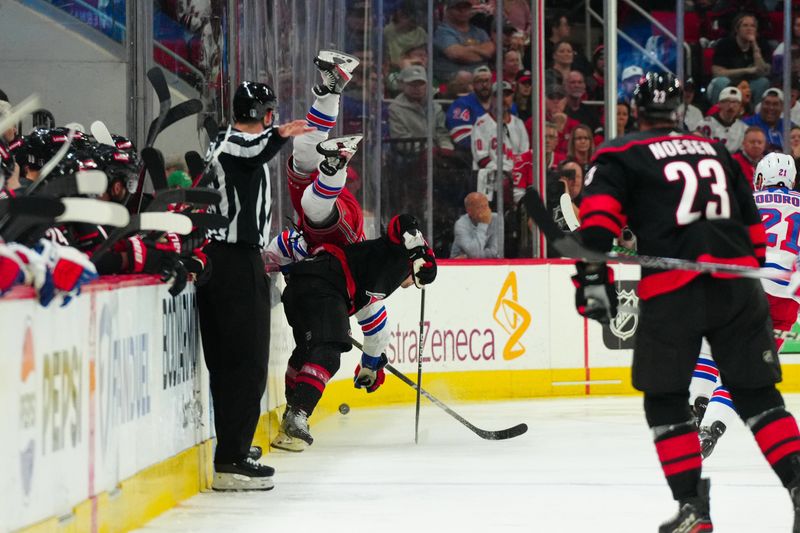 May 11, 2024; Raleigh, North Carolina, USA; Carolina Hurricanes defenseman Dmitry Orlov (7) checks New York Rangers center Jonny Brodzinski (22) during the third period in game four of the second round of the 2024 Stanley Cup Playoffs at PNC Arena. Mandatory Credit: James Guillory-USA TODAY Sports