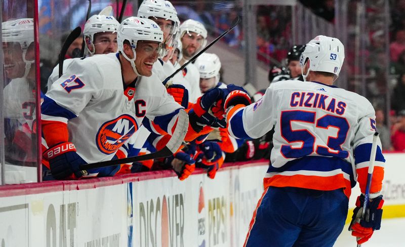 Apr 30, 2024; Raleigh, North Carolina, USA; New York Islanders center Casey Cizikas (53) celebrates his goal with New York Islanders left wing Anders Lee (27) against the Carolina Hurricanes during the second period in game five of the first round of the 2024 Stanley Cup Playoffs at PNC Arena. Mandatory Credit: James Guillory-USA TODAY Sports