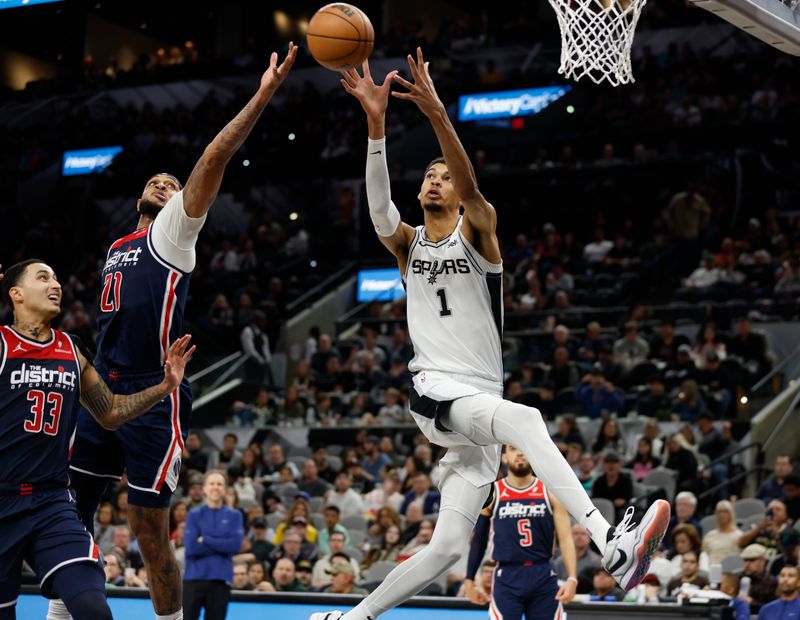 SAN ANTONIO, TX - JANUARY  29:  Victor Wembanyama #1 of the San Antonio Spurs reaches for a lob over Daniel Gafford #21 AND Kyle Kuzma #33 of the Washington Wizards in the second half at Frost Bank Center on January 29, 2024 in San Antonio, Texas. NOTE TO USER: User expressly acknowledges and agrees that, by downloading and or using this photograph, User is consenting to terms and conditions of the Getty Images License Agreement. (Photo by Ronald Cortes/Getty Images)