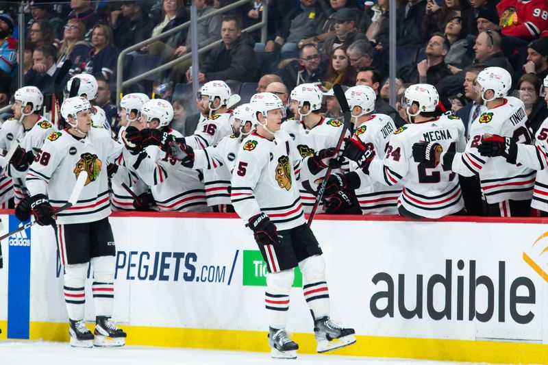 Jan 11, 2024; Winnipeg, Manitoba, CAN; Chicago Blackhawks defenseman Connor Murphy (5) is congratulated by his team mates on his goal against the Winnipeg Jets during the second period at Canada Life Centre. Mandatory Credit: Terrence Lee-USA TODAY Sports