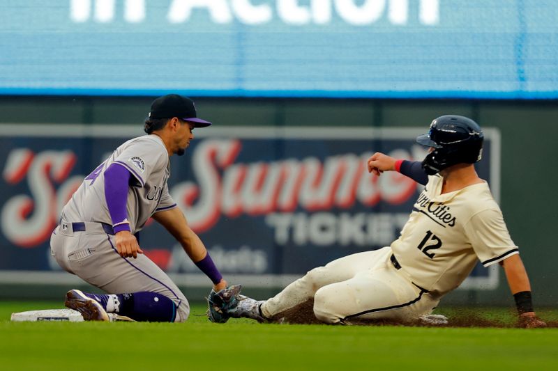 Jun 12, 2024; Minneapolis, Minnesota, USA; Colorado Rockies shortstop Ezequiel Tovar (14) tags out Minnesota Twins second baseman Kyle Farmer (12) on a stolen base attempt in the first inning at Target Field. Mandatory Credit: Bruce Kluckhohn-USA TODAY Sports