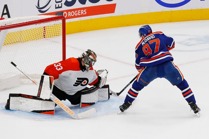 Oct 15, 2024; Edmonton, Alberta, CAN; Philadelphia Flyers goaltender Samuel Ersson (33) makes a save on  on Edmonton Oilers forward Connor McDavid (97) during overtime at Rogers Place. Mandatory Credit: Perry Nelson-Imagn Images