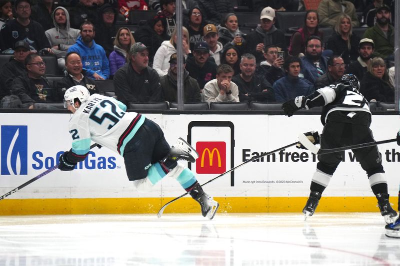 Dec 20, 2023; Los Angeles, California, USA; Seattle Kraken left wing Tye Kartye (52) is tripped by LA Kings left wing Kevin Fiala (22) in the second period at Crypto.com Arena. Mandatory Credit: Kirby Lee-USA TODAY Sports