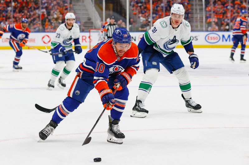 May 12, 2024; Edmonton, Alberta, CAN;Edmonton Oilers forward Derek Ryan (10) loklks to get a shot away in front of Vancouver Canucks defensemen Nikita Zadorov (91) during the third period in game three of the second round of the 2024 Stanley Cup Playoffs at Rogers Place. Mandatory Credit: Perry Nelson-USA TODAY Sports