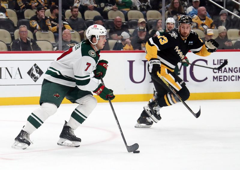 Oct 29, 2024; Pittsburgh, Pennsylvania, USA;  Minnesota Wild defenseman Brock Faber (7) moves the puck against Pittsburgh Penguins right wing Kevin Hayes (13) during the third period at PPG Paints Arena. Mandatory Credit: Charles LeClaire-Imagn Images