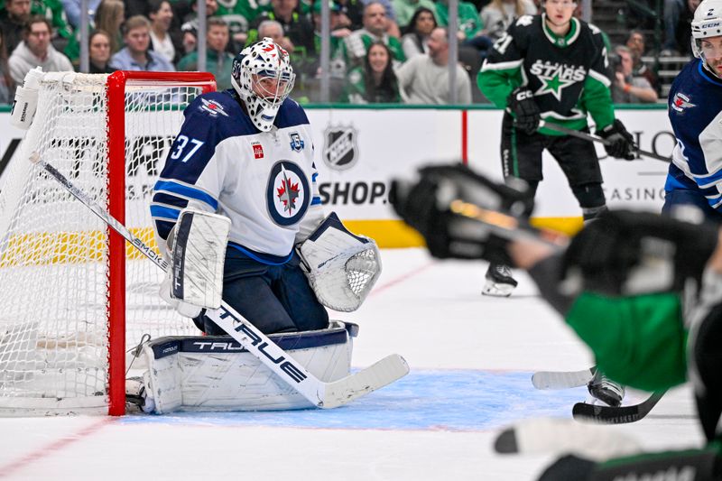 Feb 2, 2026; Dallas, Texas, USA; Dallas Stars center Wyatt Johnston (53) breaks his stick as he shoots against Winnipeg Jets goaltender Connor Hellebuyck (37) during the second period at the American Airlines Center. Mandatory Credit: Jerome Miron-Imagn Images