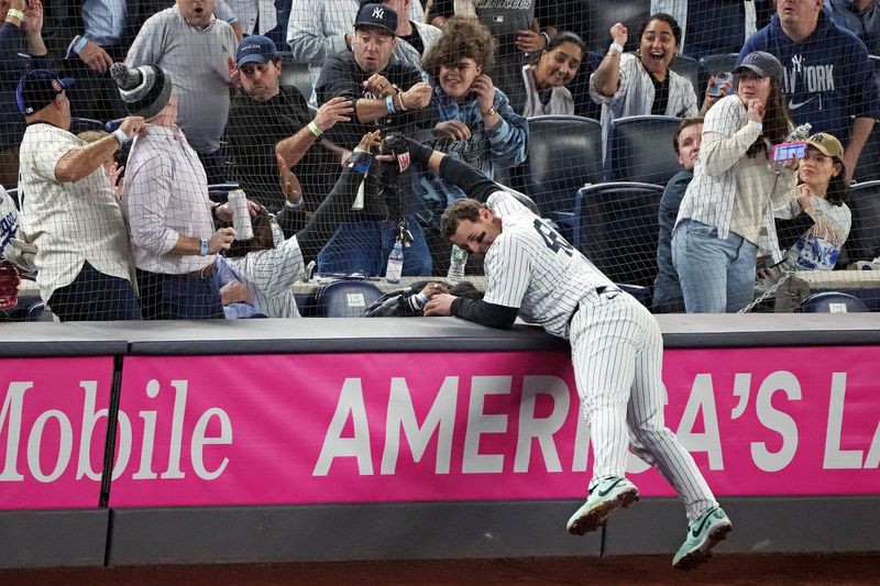 Oct 30, 2024; New York, New York, USA; New York Yankees first baseman Anthony Rizzo (48) reaches into the net for a foul ball during the fourth inning against the Los Angeles Dodgers in game four of the 2024 MLB World Series at Yankee Stadium. Mandatory Credit: Robert Deutsch-Imagn Images