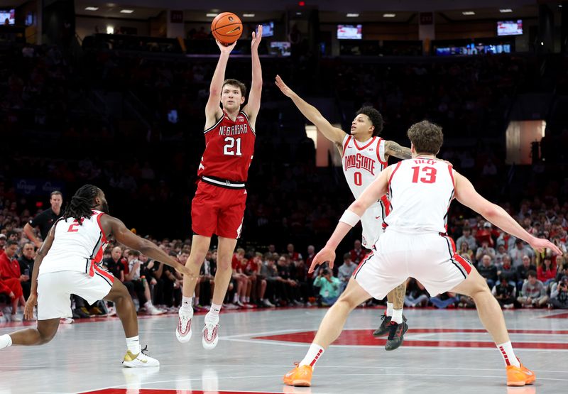 Jan 5, 2026; Columbus, Ohio, USA;  Nebraska Cornhuskers forward Pryce Sandfort (21) shoots the ball as Ohio State Buckeyes guard Bruce Thornton (2) and guard John Mobley Jr. (0) defend during the first half at Value City Arena. Mandatory Credit: Joseph Maiorana-Imagn Images