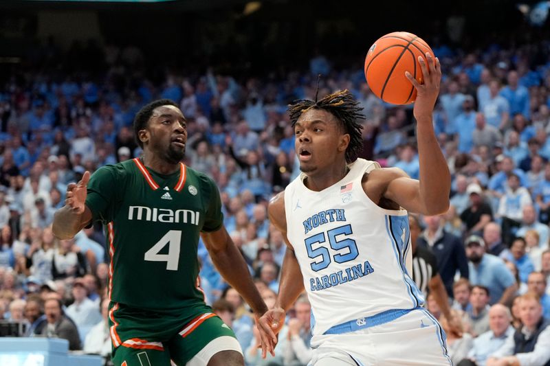 Feb 26, 2024; Chapel Hill, North Carolina, USA; North Carolina Tar Heels forward Harrison Ingram (55) with the ball as Miami (Fl) Hurricanes guard Bensley Joseph (4) defends in the second half at Dean E. Smith Center. Mandatory Credit: Bob Donnan-USA TODAY Sports