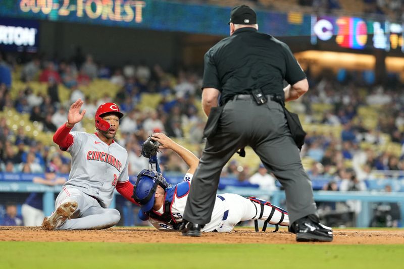 May 16, 2024; Los Angeles, California, USA; Los Angeles Dodgers catcher Austin Barnes (15) tags out Cincinnati Reds center fielder Will Benson (30) out at home plate in the ninth inning as home plate umpire Bill Miller (26) makes the call at Dodger Stadium. Mandatory Credit: Kirby Lee-USA TODAY Sports