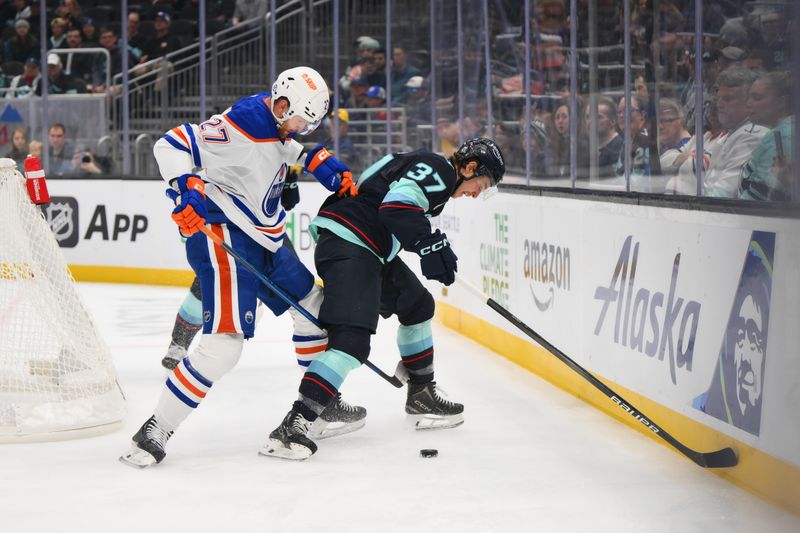 Oct 2, 2024; Seattle, Washington, USA; Seattle Kraken center Yanni Gourde (37) defends the puck from Edmonton Oilers defenseman Brett Kulak (27) during the first period at Climate Pledge Arena. Mandatory Credit: Steven Bisig-Imagn Images