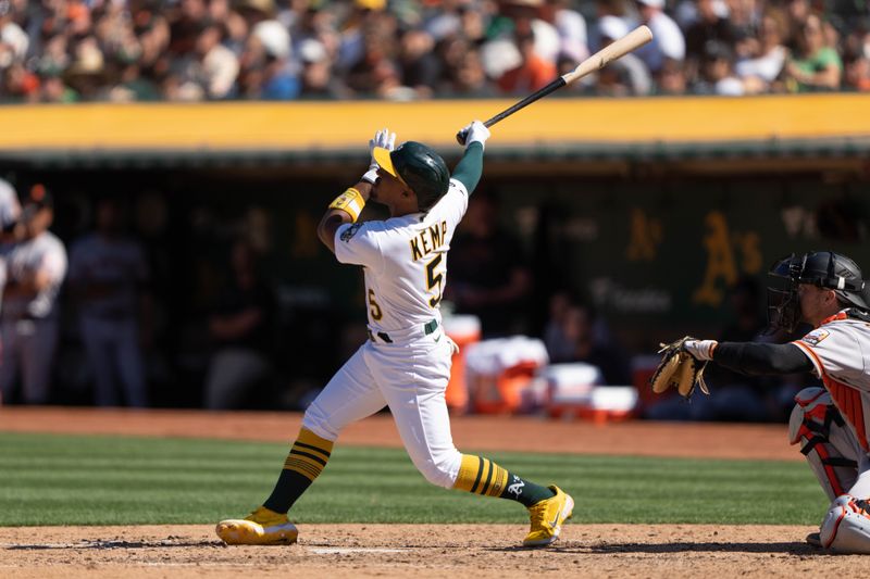 Aug 6, 2023; Oakland, California, USA;  Oakland Athletics second baseman Tony Kemp (5) hits a sacrifice fly for an RBI during the seventh inning against the San Francisco Giants at Oakland-Alameda County Coliseum. Mandatory Credit: Stan Szeto-USA TODAY Sports