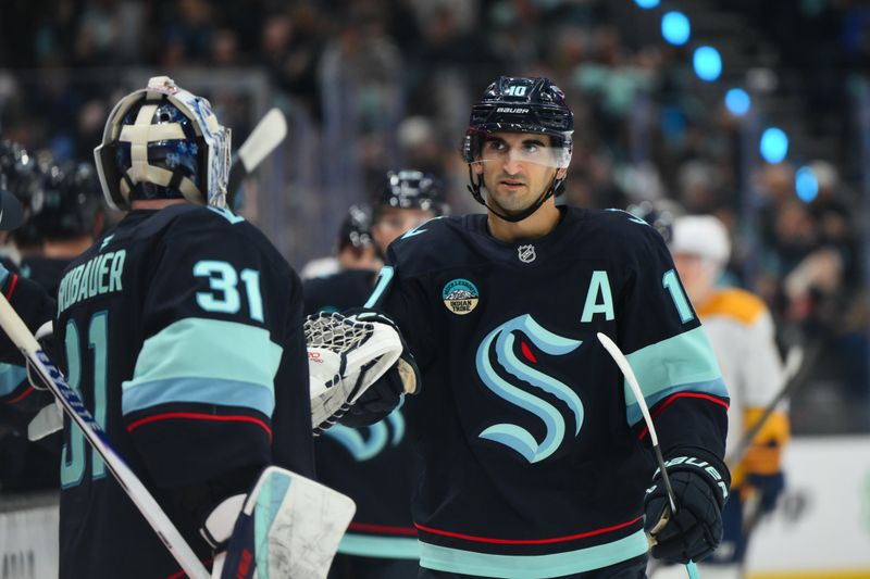 Jan 1, 2026; Seattle, Washington, USA; Seattle Kraken center Matty Beniers (10) celebrates with goaltender Philipp Grubauer (31) after scoring a goal against the Nashville Predators during the first period at Climate Pledge Arena. Mandatory Credit: Steven Bisig-Imagn Images