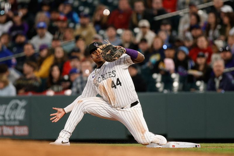 May 10, 2024; Denver, Colorado, USA; Colorado Rockies first baseman Elehuris Montero (44) is unable to field a throw at first in the seventh inning against the Texas Rangers at Coors Field. Mandatory Credit: Isaiah J. Downing-USA TODAY Sports