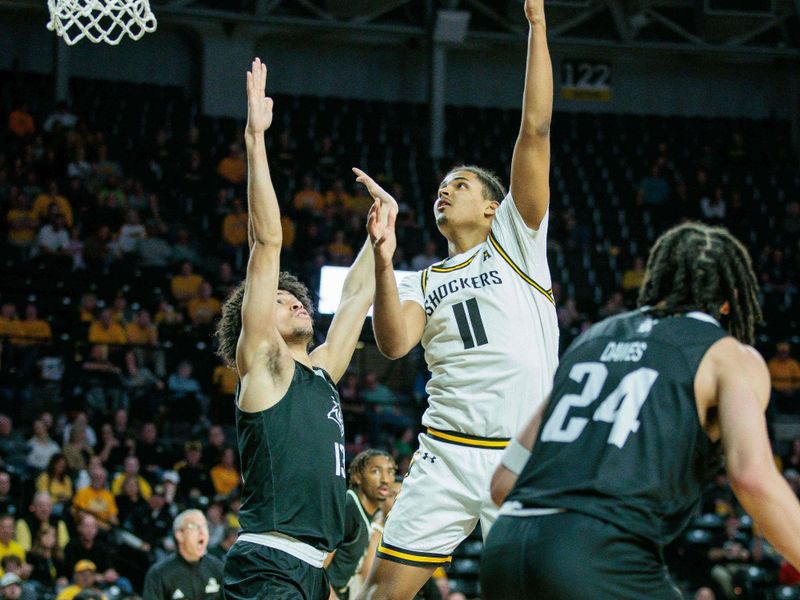 Mar 2, 2024; Wichita, Kansas, USA; Wichita State Shockers forward Kenny Pohto (11) shoots the ball over Rice Owls forward Andrew Akuchie (13) during the first half at Charles Koch Arena. Mandatory Credit: William Purnell-USA TODAY Sports