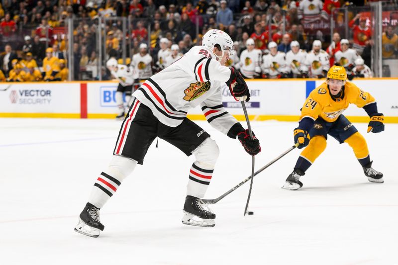 Jan 16, 2025; Nashville, Tennessee, USA;  Chicago Blackhawks center Colton Dach (28) takes a shot on goal against the Nashville Predators during the second period at Bridgestone Arena. Mandatory Credit: Steve Roberts-Imagn Images