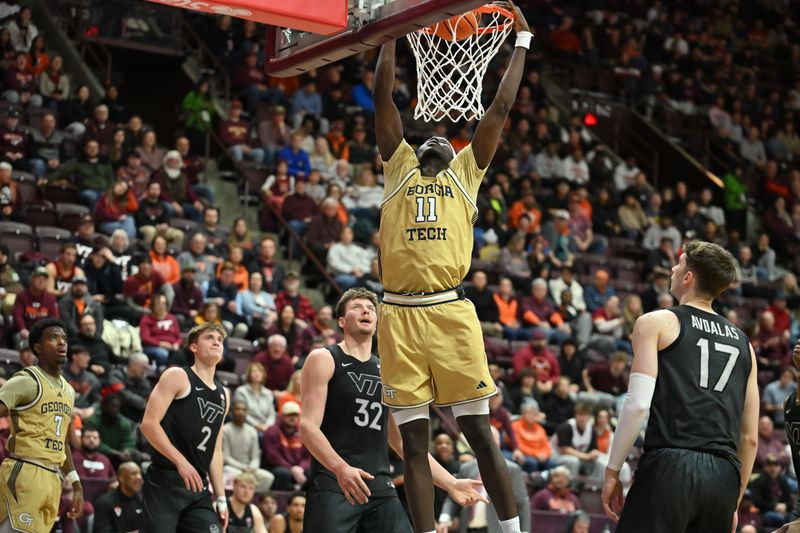 Jan 27, 2026; Blacksburg, Virginia, USA;  Georgia Tech Yellow Jackets forward Baye Ndongo (11) dunks the ball as Virginia Tech Hokies guard Neoklis Avdalas (17) ad Virginia Tech Hokies center Christian Gurdak (32) watch during the first half at Cassell Coliseum. Mandatory Credit: Brian Bishop-Imagn Images