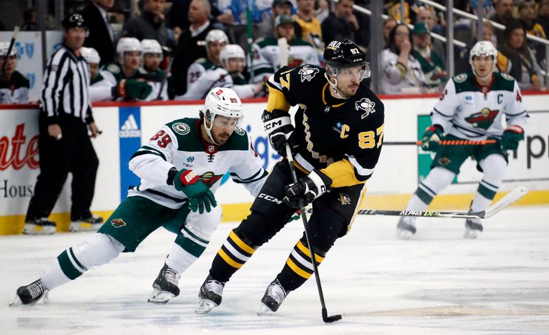 Apr 6, 2023; Pittsburgh, Pennsylvania, USA; Pittsburgh Penguins center Sidney Crosby (87) moves the puck against Minnesota Wild center Frederick Gaudreau (89) during the first period at PPG Paints Arena. Mandatory Credit: Charles LeClaire-USA TODAY Sports