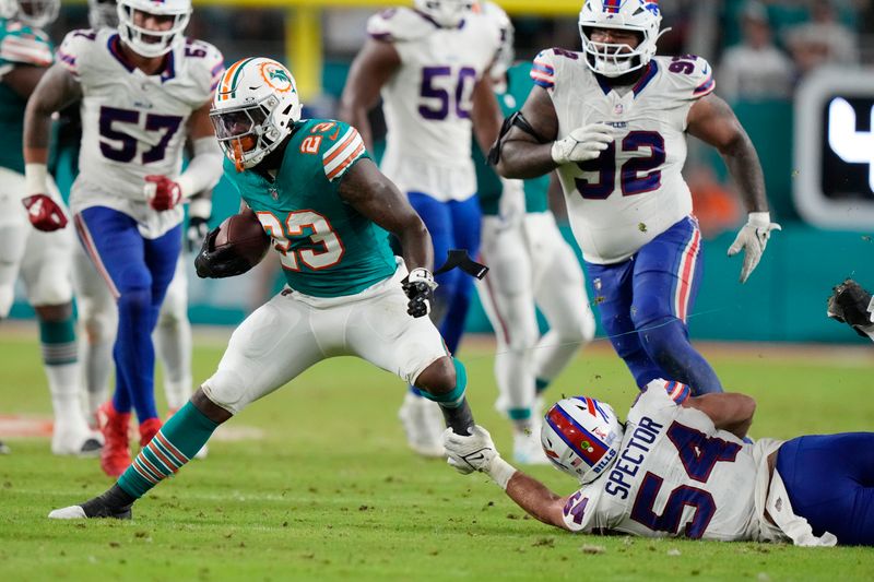 Buffalo Bills linebacker Baylon Spector (54) attempts to grab Miami Dolphins running back Jeff Wilson Jr. (23) during the first half of an NFL football game, Thursday, Sept. 12, 2024, in Miami Gardens, Fla. (AP Photo/Lynne Sladky)