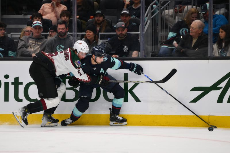 Apr 9, 2024; Seattle, Washington, USA; Seattle Kraken right wing Jordan Eberle (7) plays the puck while defended by Arizona Coyotes defenseman Michael Kesselring (5) during the second period at Climate Pledge Arena. Mandatory Credit: Steven Bisig-USA TODAY Sports