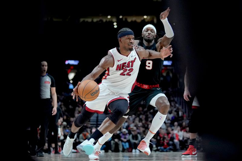 PORTLAND, OREGON - FEBRUARY 27: Jimmy Butler #22 of the Miami Heat dribbles the ball while defended by Jerami Grant #9 of the Portland Trail Blazers during the second half at Moda Center on February 27, 2024 in Portland, Oregon. NOTE TO USER: User expressly acknowledges and agrees that, by downloading and or using this photograph, User is consenting to the terms and conditions of the Getty Images License Agreement. (Photo by Soobum Im/Getty Images)