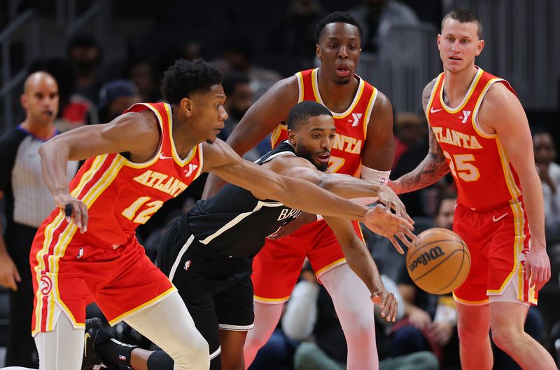 ATLANTA, GEORGIA - DECEMBER 06:  Mikal Bridges #1 of the Brooklyn Nets draws a foul from De'Andre Hunter #12 of the Atlanta Hawks during the first quarter at State Farm Arena on December 06, 2023 in Atlanta, Georgia.  NOTE TO USER: User expressly acknowledges and agrees that, by downloading and/or using this photograph, user is consenting to the terms and conditions of the Getty Images License Agreement.  (Photo by Kevin C. Cox/Getty Images)