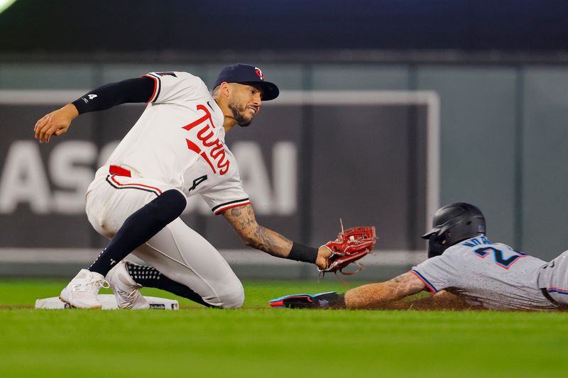 Sep 24, 2024; Minneapolis, Minnesota, USA; Minnesota Twins' Carlos Correa (4) tags out Miami Marlins third baseman Connor Norby (24) on an attempted steal in the seventh inning at Target Field. Mandatory Credit: Bruce Kluckhohn-Imagn Images