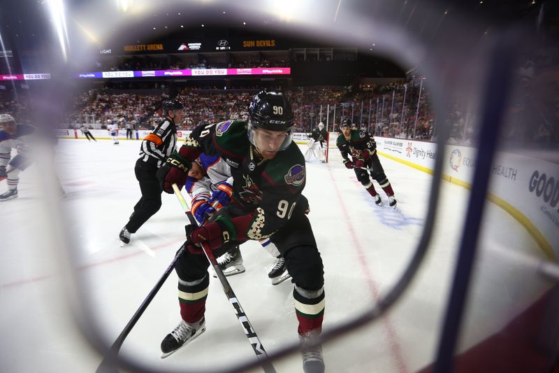 Apr 17, 2024; Tempe, Arizona, USA;  Arizona Coyotes defenseman J.J. Moser (90) controls the puck during the third period of the game against the Edmonton Oilers at Mullett Arena. Mandatory Credit: Mark J. Rebilas-USA TODAY Sports