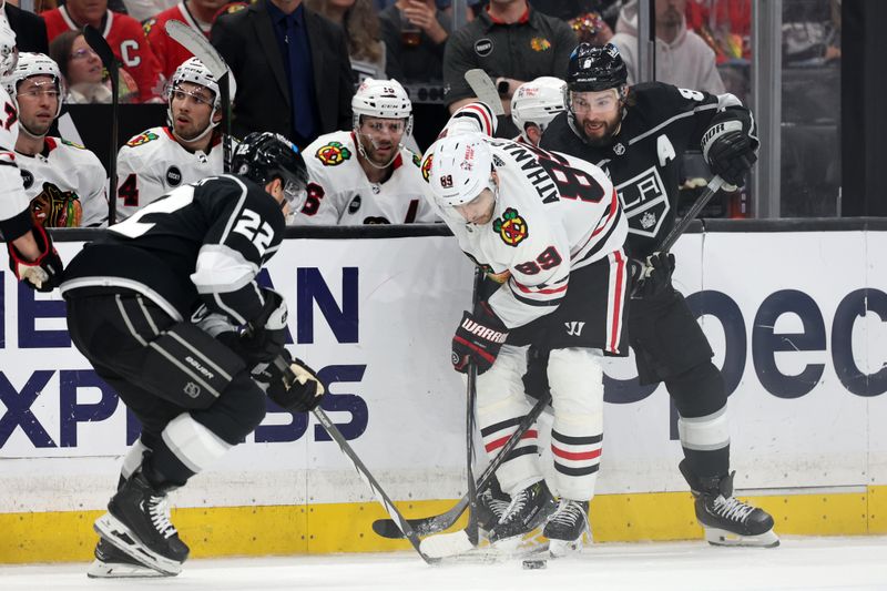 Mar 19, 2024; Los Angeles, California, USA;  Chicago Blackhawks center Andreas Athanasiou (89) fights for the puck against Los Angeles Kings left wing Kevin Fiala (22) and defenseman Drew Doughty (8) during the third period at Crypto.com Arena. Mandatory Credit: Kiyoshi Mio-USA TODAY Sports