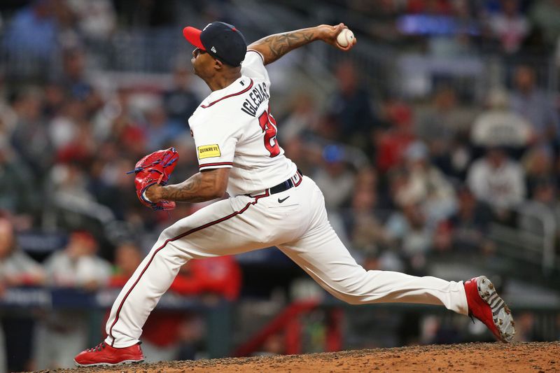 Oct 7, 2023; Cumberland, Georgia, USA; Atlanta Braves relief pitcher Raisel Iglesias (26) pitches during the ninth inning against the Philadelphia Phillies during game one of the NLDS for the 2023 MLB playoffs at Truist Park. Mandatory Credit: Brett Davis-USA TODAY Sports