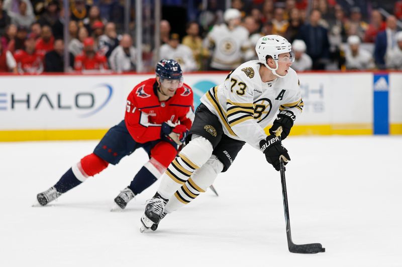 Apr 15, 2024; Washington, District of Columbia, USA; Boston Bruins defenseman Charlie McAvoy (73) skates with the puck as Washington Capitals left wing Max Pacioretty (67) chases in the first period at Capital One Arena. Mandatory Credit: Geoff Burke-USA TODAY Sports