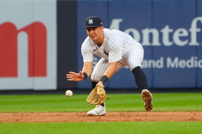 Jun 22, 2023; Bronx, New York, USA; New York Yankees shortstop Anthony Volpe (11) fields a ground ball hit by Seattle Mariners center fielder Julio Rodriguez (not pictured) during the second inning at Yankee Stadium. Mandatory Credit: Gregory Fisher-USA TODAY Sports