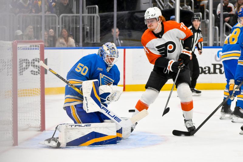 Nov 30, 2024; St. Louis, Missouri, USA;  St. Louis Blues goaltender Jordan Binnington (50) defends the net against Philadelphia Flyers right wing Owen Tippett (74) during the first period at Enterprise Center. Mandatory Credit: Jeff Curry-Imagn Images