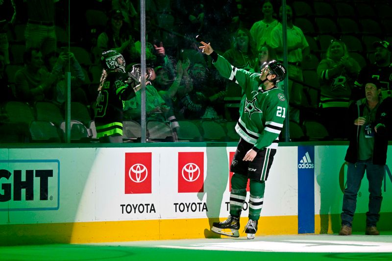 Apr 3, 2023; Dallas, Texas, USA; Dallas Stars left wing Jason Robertson (21) throws a puck to a fan after the victory over the Nashville Predators at the American Airlines Center. Mandatory Credit: Jerome Miron-USA TODAY Sports