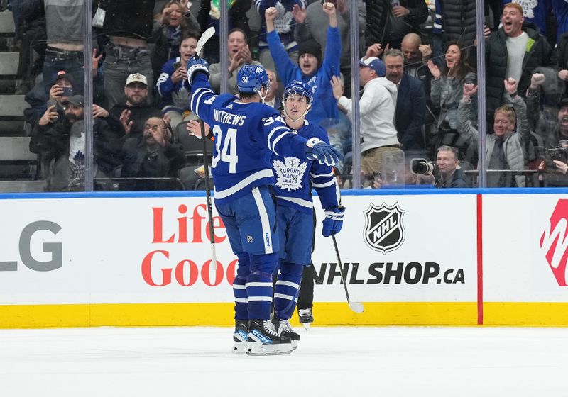 Mar 6, 2024; Toronto, Ontario, CAN; Toronto Maple Leafs center Auston Matthews (34) scores the winning goal and celebrates with Toronto Maple Leafs right wing Mitchell Marner (16) against the Buffalo Sabres during the overtime period at Scotiabank Arena. Mandatory Credit: Nick Turchiaro-USA TODAY Sports