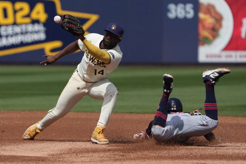 Mar 16, 2025; Phoenix, Arizona, USA; Milwaukee Brewers third base Andruw Monasterio (14) tries to tag Cleveland Guardians outfielder Tyler Freeman (2) in the first inning at American Family Fields of Phoenix. Mandatory Credit: Rick Scuteri-Imagn Images