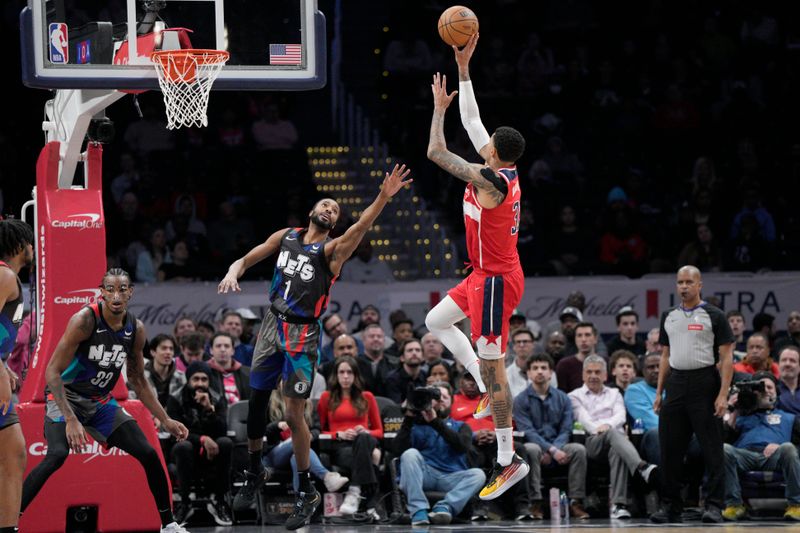 WASHINGTON, DC - MARCH 27: Kyle Kuzma #33 of the Washington Wizards shoots against Mikal Bridges #1 of the Brooklyn Nets during the first half at Capital One Arena on March 27, 2024 in Washington, DC. NOTE TO USER: User expressly acknowledges and agrees that, by downloading and or using this photograph, User is consenting to the terms and conditions of the Getty Images License Agreement. (Photo by Jess Rapfogel/Getty Images)