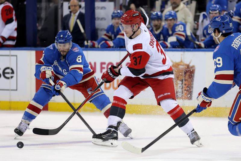 Feb 5, 2026; New York, New York, USA; Carolina Hurricanes right wing Andrei Svechnikov (37) fights for the puck against New York Rangers left wing J.T. Miller (8) and defenseman Matthew Robertson (29) during the third period at Madison Square Garden. Mandatory Credit: Brad Penner-Imagn Images