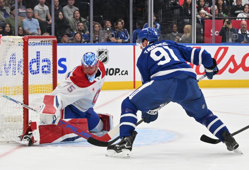 Sep 26, 2024; Toronto, Ontario, CAN;  Toronto Maple Leafs forward John Tavares (91) scores a goal past Montreal Canadiens goalie Jakub Dobes (75) in the first period at Scotiabank Arena. Mandatory Credit: Dan Hamilton-Imagn Images