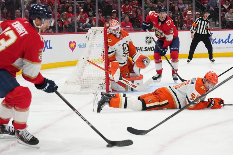 Oct 28, 2025; Sunrise, Florida, USA; Anaheim Ducks goaltender Lukas Dostal (1) keeps his eye on the puck as defenseman Pavel Mintyukov (98) tries to block the shot of Florida Panthers center Sam Reinhart (13) during the second period at Amerant Bank Arena. Mandatory Credit: Jim Rassol-Imagn Images