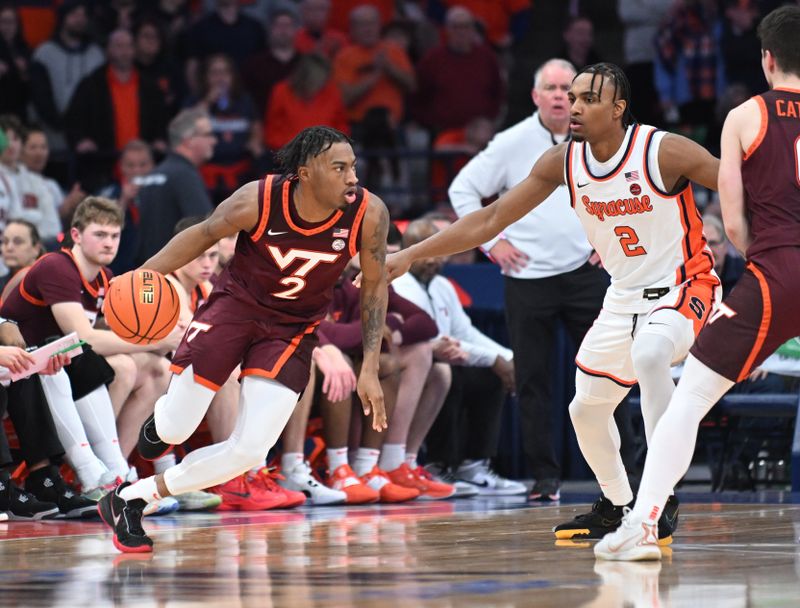 Feb 27, 2024; Syracuse, New York, USA; Virginia Tech Hokies guard MJ Collins (left) drives the ball as Syracuse Orange guard JJ Starling defends in the second half at the JMA Wireless Dome. Mandatory Credit: Mark Konezny-USA TODAY Sports