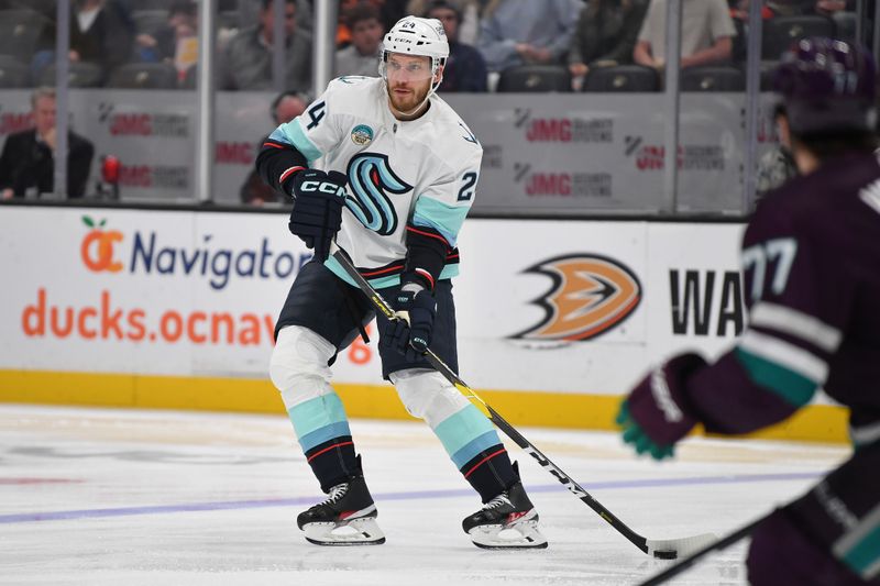 Dec 23, 2023; Anaheim, California, USA; Seattle Kraken defenseman Jamie Oleksiak (24) controls the puck against the Anaheim Ducks during the first period at Honda Center. Mandatory Credit: Gary A. Vasquez-USA TODAY Sports