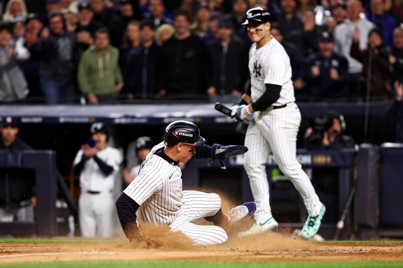 Oct 14, 2024; Bronx, New York, USA; New York Yankees outfielder Aaron Judge (99) slides into home plate to score a run on a wild pitch during the third inning against the Cleveland Guardians in game one of the ALCS for the 2024 MLB Playoffs at Yankee Stadium. Mandatory Credit: Wendell Cruz-Imagn Images