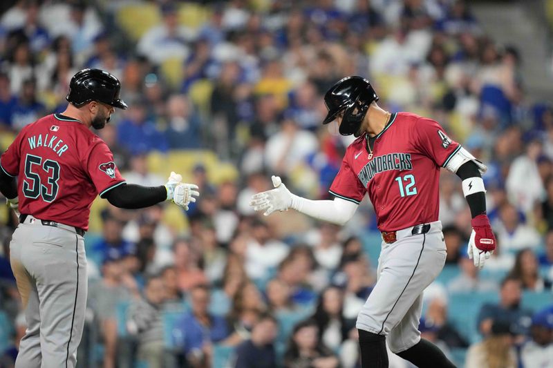 Jul 3, 2024; Los Angeles, California, USA; Arizona Diamondbacks left fielder Lourdes Gurriel Jr. (12) celebrates with first baseman Christian Walker (53) after hitting a two-run home run in the sixth inning against the Los Angeles Dodgers at Dodger Stadium. Mandatory Credit: Kirby Lee-USA TODAY Sports