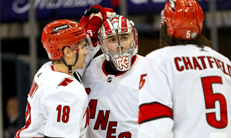 Jan 2, 2024; New York, New York, USA; Carolina Hurricanes goalie Pyotr Kochetkov (52) celebrates a 6-1 win against the New York Rangers with center Jack Drury (18) and defenseman Jalen Chatfield (5) at Madison Square Garden. Mandatory Credit: Danny Wild-USA TODAY Sports